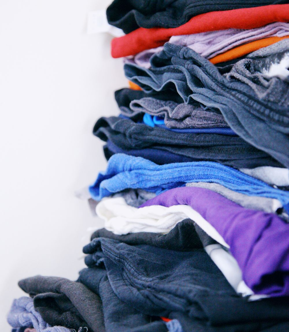 Neatly folded laundry sorted into soft colour-coordinated stacks